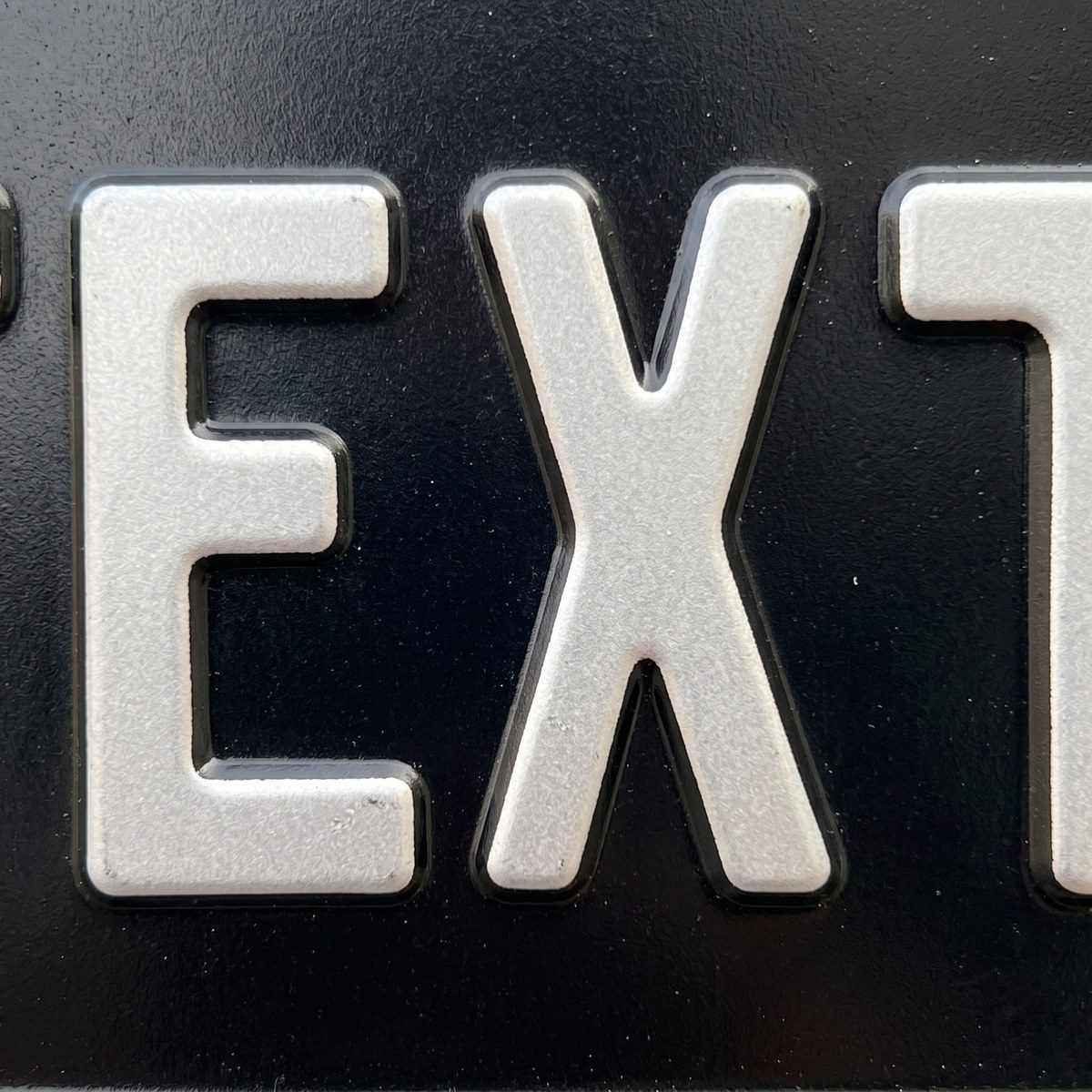 Detalhe aproximado das letras em alto relevo prensado
