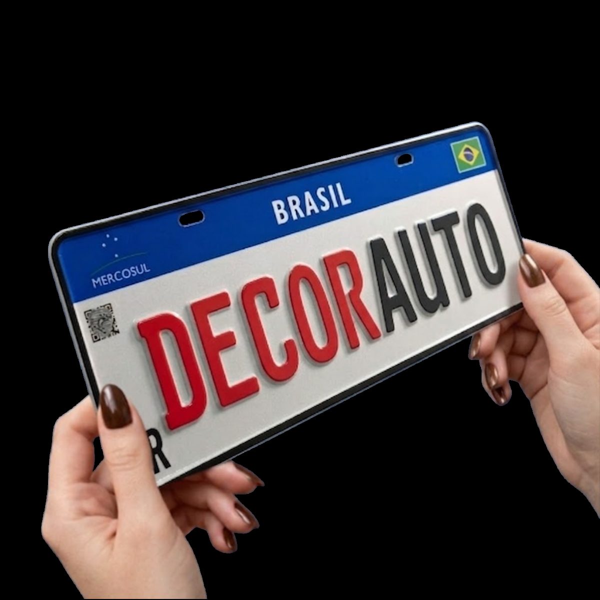 Placa Mercosul segurada em duas mãos, mostrando o tamanho real da peça