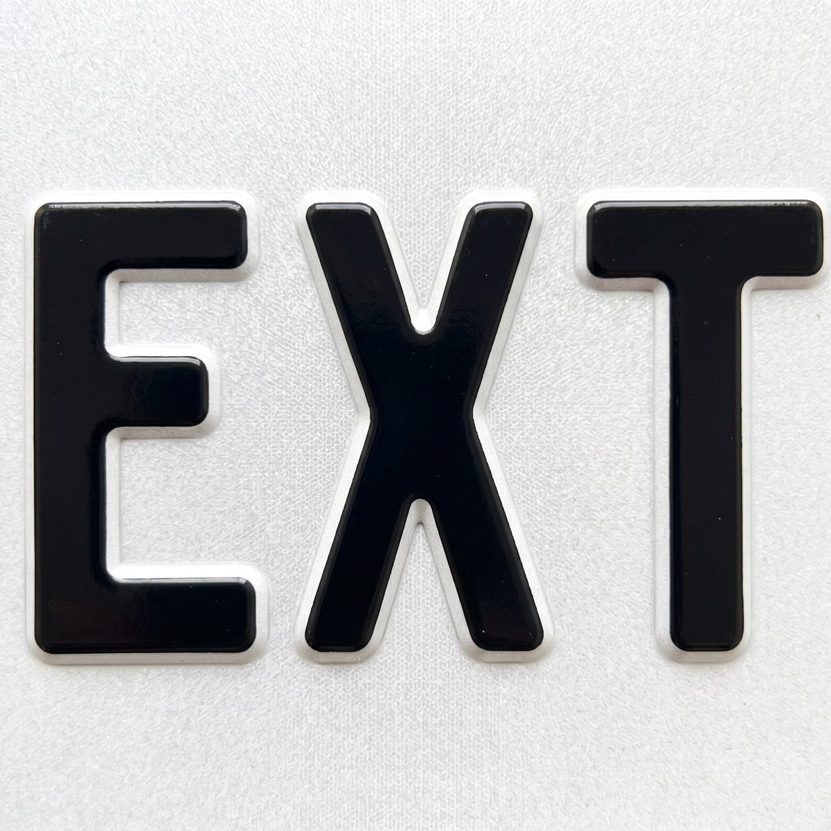 Detalhe aproximado das letras em alto relevo prensado