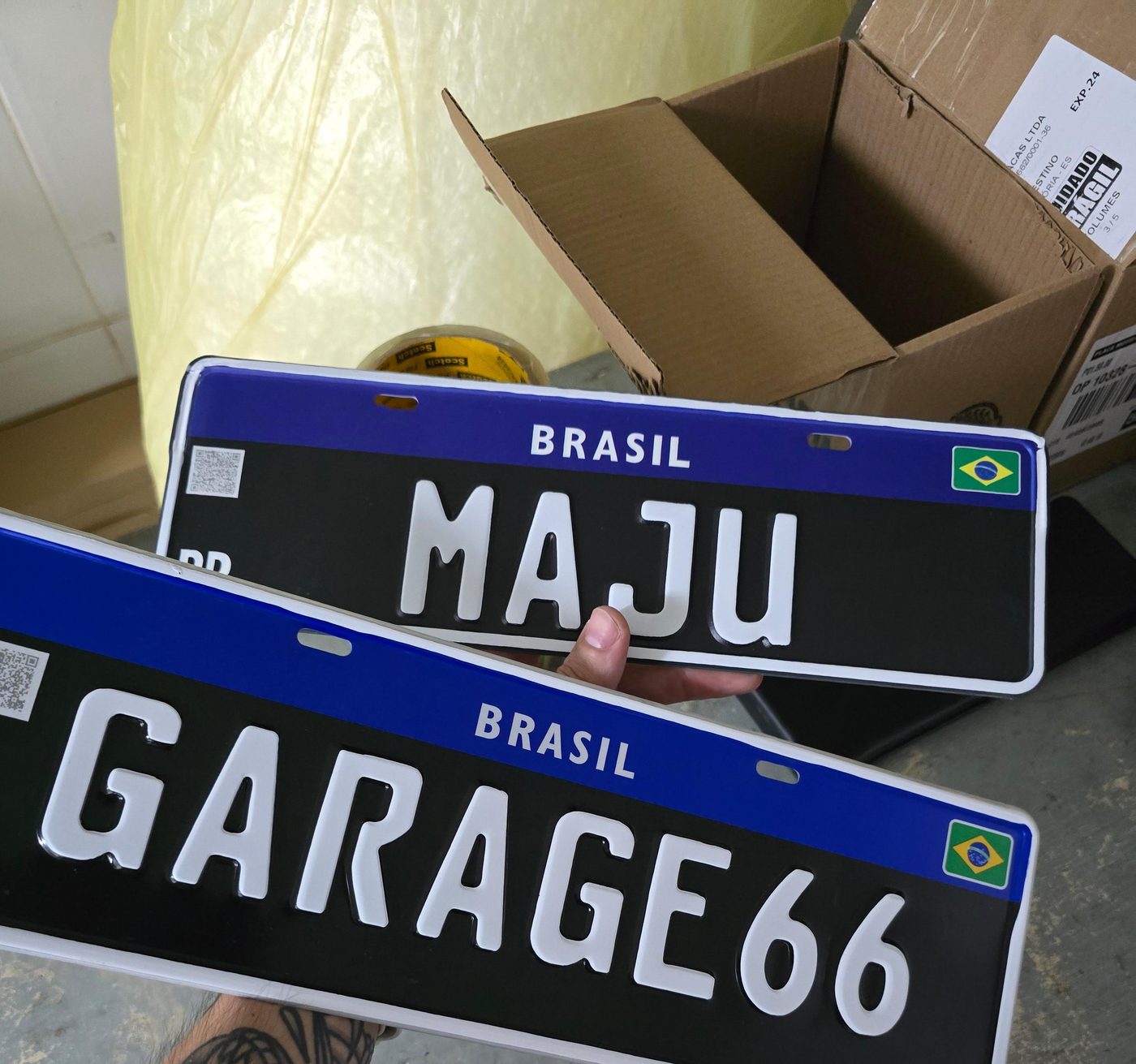 Duas placas Colecionador pretas na oficina, prontas para embalar