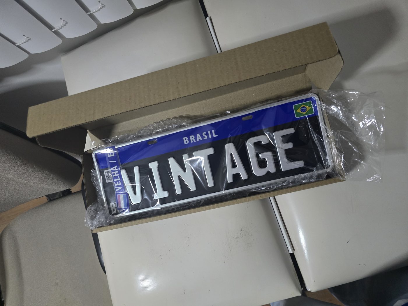 Placa Colecionador preta com faixa lateral personalizada, na caixa aberta